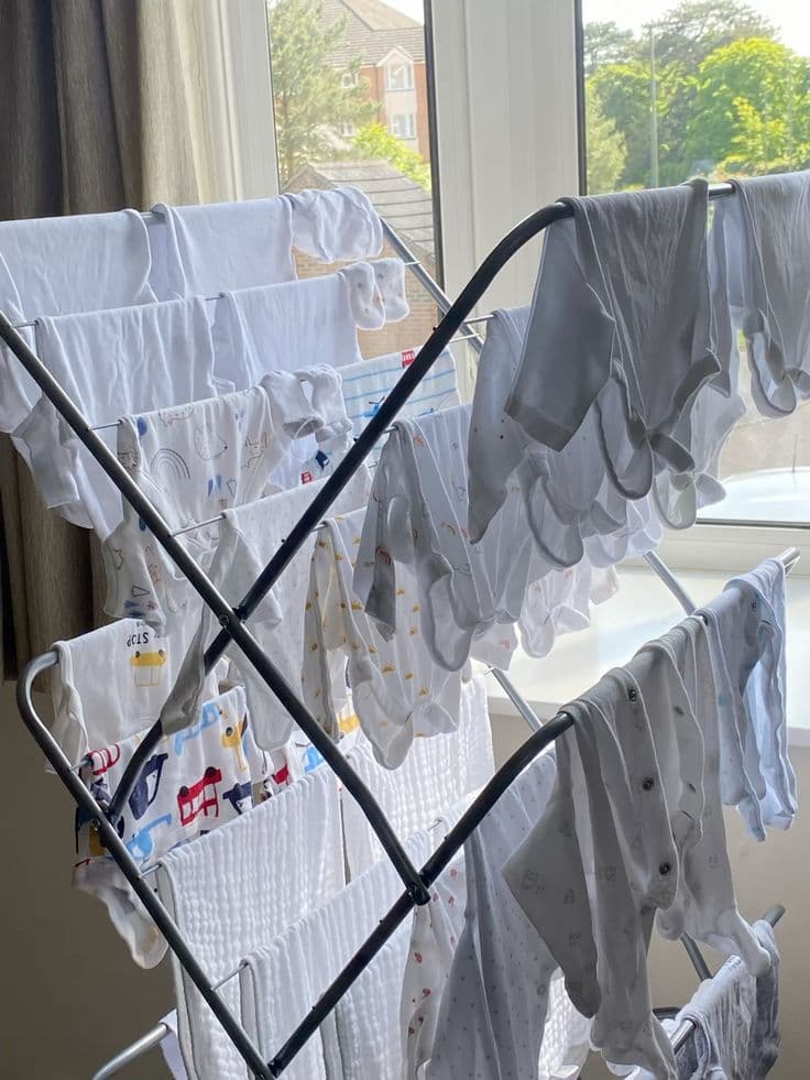 Freshly washed linen drying on a rack by the window between stays